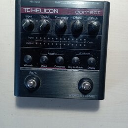 Černý efekt pedál s nápisy TC-HELICON a correct. Zařízení má pět otočných ovladačů s popisky Input, Shape, Compress, De-ess a Pitch, několik tlačítek…