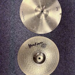 Dvě mosazné činely typu hi-hat s koncentrickým rýhováním. Horní činel má nápisy „Sottom Hi-Hat“ a „14"/35,5cm“ a logo „Pearl“. Dolní činel nese nápis…