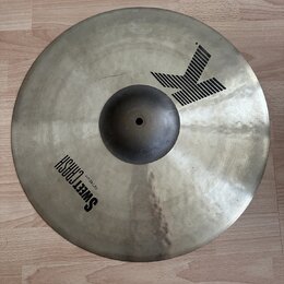 Kovový činel v matné stříbrno-zlaté barvě s viditelnou strukturou povrchu. Na povrchu je černý nápis SWEET CRASH a menší text 19" / 48 cm. V horní čá…