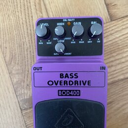 Fialový efekt pedál s nápisy BASS OVERDRIVE a BOD400. V horní části jsou čtyři ovládací knoflíky s popisky LEVEL, HIGH, GAIN a BAL. Pod nimi se nachá…