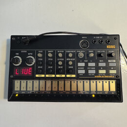 Černý drum machine s nápisy KORG a volta beats. Zařízení obsahuje několik otočných potenciometrů, tlačítek a červený digitální displej s viditelným t…