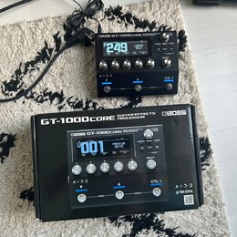 Černý efektový procesor Boss GT-1000CORE s digitálním displejem a několika ovládacími knoflíky. Na zařízení je vidět nápis BOSS GT-1000CORE GUITAR EF…