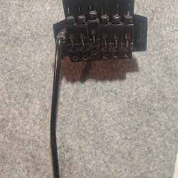 Černý kobylkový systém pro elektrickou kytaru s pákou. Na pravé straně je vidět nápis „Ibanez EDGE“. Povrch vykazuje známky opotřebení a oxidace v ob…