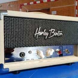 Malý kytarový kombozesilovač v krémovém vinylu s černou textilní maskou. Na přední straně je bílý nápis Harley Benton a zrcadlový ovládací panel s kn…