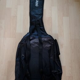 Černý textilní obal na hudební nástroj s ramenními popruhy a boční kapsou. Na horní části je bílý nápis ROCK BAG a pod ním menší text by HARLEY BENTO…