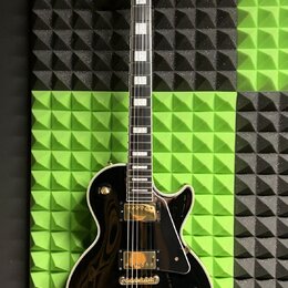 Černá elektrická kytara s tmelem hmatníkem a bílými blokovými vložkami. Na hlavě je bílé logo Epiphone a symbol v podobě kosočtverce. Tělo je lesklé,…
