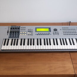 Stříbrný digitální klavír s klávesnicí. Na levé straně je logo YAMAHA a vpravo nápis MOTIF ES6. Nástroj má centrální displej, několik posuvníků a sad…