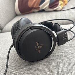 Černá velká sluchátka s uzavřeným provedením a koženým polstrováním náušníků. Na vnější straně náušníku je nápis audio-technica a modelové označení A…