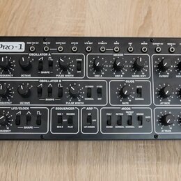 Černý analogový syntetizátor s nápisem PRO-1 a logem behringer. Přední panel obsahuje množství černých otočných ovladačů, přepínačů a zapojovacích ko…