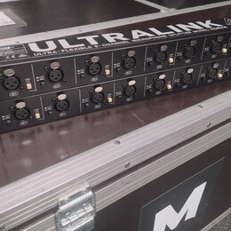 Dvě černé rackové jednotky s nápisy ULTRALINK a ULTRA-FLEXIBLE 6-CHANNEL MICROPHONE SPLITTER MODEL MS8000. Na předním panelu jsou vidět vstupy, přepí…