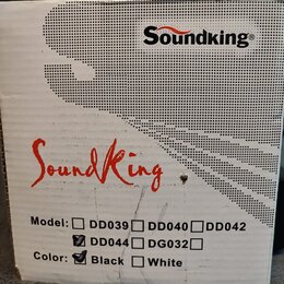 Fotografie znázorňuje část bílého kartónového obalu. V horní části je černý nápis Soundking® a uprostřed červený nápis SoundKing. Dole jsou uvedeny m…