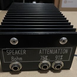 Černý kovový přístroj s výrazným chladicím žebrováním. Na přední straně je štítek s nápisy SPEAKER 8ohm a ATTENUATION 75% 91%. Přístroj obsahuje tři…