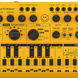 Žlutý analogový basový syntetizátor s nápisem TD-3-MO Modded Out Analog Bass Line Synthesizer. Přístroj obsahuje zahlreiche černé ovládací knofíky, p…