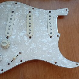 Bílá pickguard s perleťovým efektem pro elektrickou kytaru. Je na ní osazeno tři bílé snímače s jednoduchými krytkami, jeden přepínač a tři ovládací…