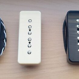 Fotografie zobrazuje pět elektrických snímačů kytary v různých provedeních. Zleva jsou dva černí humbuckery s nápisem Seymour Duncan, jeden krémový j…