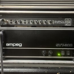 V hliníkovém racku jsou umístěna dvě černá zařízení značky Ampeg. Horní jednotka nese nápis SVPCL ALL TUBE BASS PREAMP a má řadu ovládacích knoflíků…