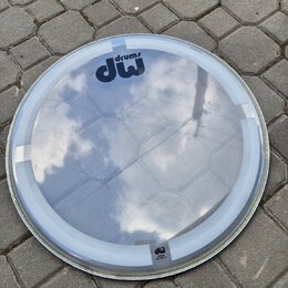 Průhledná kruhová bubenová blana s bílým okrajem. V horní části je černé logo „drums dw“. V dolní části je menší nápis „dw“ a pod ním nečitelný text.…