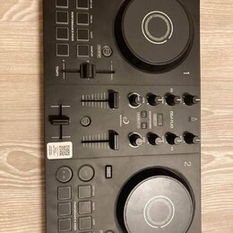 Černý DJ kontrolér s dvěma jog-koly, faderem a řadou ovládacích tlačítek a posuvníků. Na přístroji je vidět nápis DDJ-FLX2, logo AlphaTheta a označen…