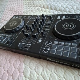 Černý DJ kontrolér s dvěma jog-koly a centrálním mixážním sekcí. Na přístroji jsou viditelný nápisy Pioneer DJ a rekordbox. Povrch je v dobrém stavu,…