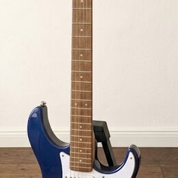 Modře lakovaná elektrická kytara s bílým pickguardem a světle hnědým hnedem hmatníkem. Na hlavě je viditelné logo Yamaha a nápis PACIFICA. Nástroj má…