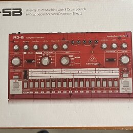Fotografie znázorňuje krabici s červeným analogovým bicím automatem. Na krabici je nápis RD-6-SB Analog Drum Machine with 8 Drum Sounds, 64 Step Sequ…