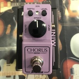 Fialový efekt pedál s nápisy CHORUS MINI a logem Ibanez. Na horní části jsou dva malé černé oválné knoflíky s popisky DEPTH a LEVEL, jeden velký čern…