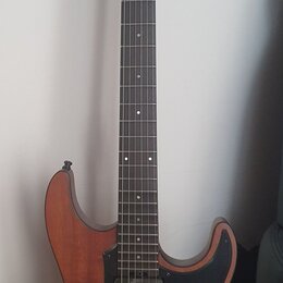 Elektrická kytara s hnědým dřevěným korpusem a černým pickguardem. Na hlavě hmatníku je bílý nápis LTD Deluxe. Nástroj má tři snímače, jeden ovládací…