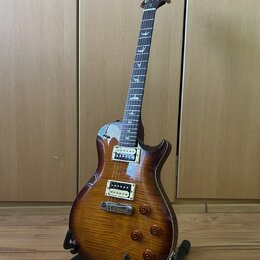Elektrická kytara s prohnutou deskou z plaménového dřeva v hnědém sunburst provedení. Na hmatníku jsou vyznačeny vložky ve tvaru ptáků a na hlavě je…