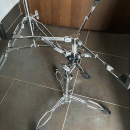 Stříbrný kovový stojan s trojramennou základnou a černými gumovými koncovkami. Konstrukce obsahuje několik nastavovacích šroubů a klouzevých mechanis…