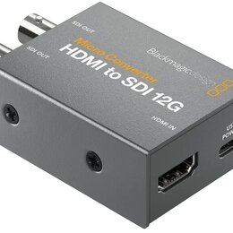 Šedý kovový konvertor s nápisy Micro Converter, HDMI to SDI 12G a Blackmagicdesign. Zařízení má dva výstupy označené jako SDI OUT, jeden vstup HDMI I…