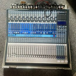 Šedý mixážní pult s modrými prvky a bílými popisky. V levém horním rohu je nápis STUDIOLIVE 24.4.2 a v pravém horním rohu logo PreSonus. Zařízení obs…