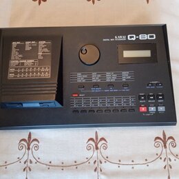 Černý digitální MIDI sekvencer s nápisem KAWAI Q-80 DIGITAL MIDI SEQUENCER. Zařízení má malý displej, ovládací tlačítka a vlevo slot pro diskety. Pov…