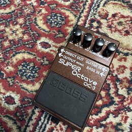 Hnědý efekt pedál s černým spínacím tlačítkem a čtyřmi ovládacími knoflíky. Na horní části jsou nápisy DIRECT OUT, GUITAR IN, OUTPUT (MONO), BASS IN…