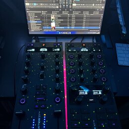 Fotografie zachycuje černý DJ kontrolér Traktor Z1, který je připojen k notebooku s otevřeným softwarem TRAKTOR PRO 4. Na zařízení jsou vidět dva mod…