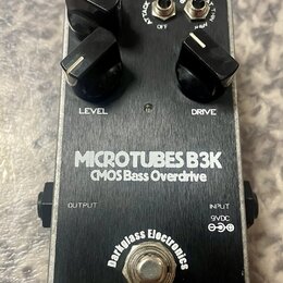 Stompbox s kovovým stříbrným povrchem a černým spodním panelem. Na horní části jsou tři černé ovládací knoflíky s popisky LEVEL a DRIVE, dva přepínač…