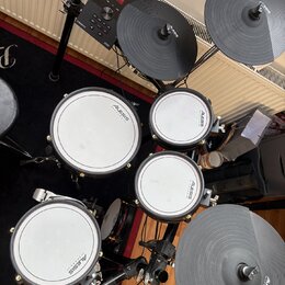 Elektronická bicí souprava značky Alesis. Na module je nápis Alesis a Crimson 1, na bubnech jsou viditelná loga Alesis. Souprava obsahuje čtyři bílé…