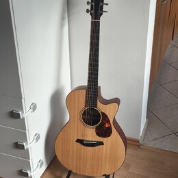 Akustická kytara s cutawayem, přírodní barvou desky a tmavými boky. Na hlavě hmatníku je viditelné bílé logo ve tvaru stylizovaného písmene F. Nástro…