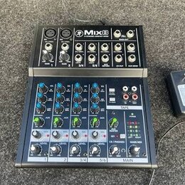 Černý kompaktní mixážní pult s nápisem Mix8 8-CHANNEL COMPACT MIXER. Horní část obsahuje vstupy Gain a AUX, spodní část je vybavena modrými a zeleným…