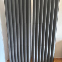 Dva šedé akustické panely s vlnovitým povrchem. Panely jsou umístěny na černých základnách. Na povrchu nejsou vidět žádné značky ani nápisy.