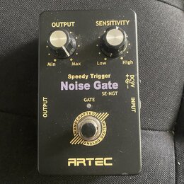 Černý efekt pedál s nápisy Speedy Trigger Noise Gate a SE-NGT. Na horní straně jsou dva ovládací knoflíky s popisky OUTPUT (Min, Max) a SENSITIVITY (…