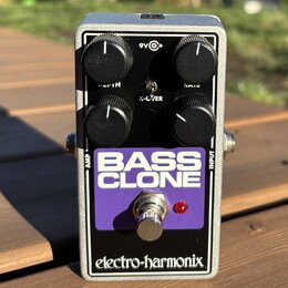Stříbrný efekt pedál v kovovém šasi s fialovým panelem. Na panelu je bílý nápis BASS CLONE a v dolní části černý pruh s bílým logem electro-harmonix.…