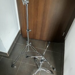 Stříbrný kovový mikrofonní stojan s trojnožkou a teleskopickým středovým sloupem. Horní část obsahuje držák pro mikrofon s černou gumovou vložkou a u…