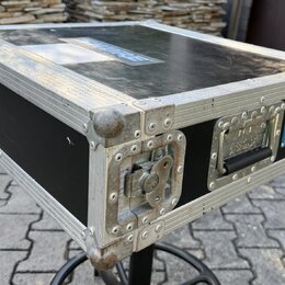 Černý transportní case s hliníkovými hranami a kovovými rohy. Na pravé straně je modrý štítek s nápisy THT CASE a thtcase.cz. Povrch hliníkových prof…
