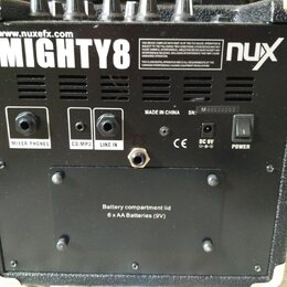 Zadní strana černého komba s nápisy www.nuxefx.com, MIGHTY8 a logem nux. Jsou zde vidět vstupy a výstupy s popisky MIXER PHONES, CD/MP3, LINE IN, DC…