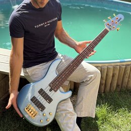 Modrá elektrická basová kytara s kovovými zlatými prvky. Na hlavě nástroje je bílý nápis YAMAHA. Instrument má čtyři struny a dva snímače v korpusu.…