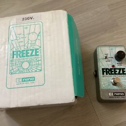 Na fotografii je efekt pedál v šedém kovovém provedení a jeho původní bílo-zelená krabice. Na pedálu i na krabici je uveden nápis FREEZE SOUND RETAIN…