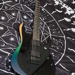 Elektrická kytara s černým bodies, které má na horním vyřezu přechod barev od dřevěné přes zelenou až po modrou. Nástroj má dva humbuckery, jeden ovl…