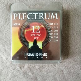 Balení kytarových strun v průhledném plastovém obalu. Na obalu je nápis PLECTRUM, kód AC210 a označení 12 STRING SET. V dolní části je uveden výrobce…