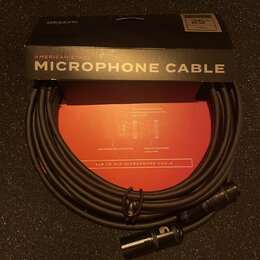 Černý mikrofonní kabel s konektory XLR, umístěný před svým originálním černým a červeným obalem. Na krabici jsou nápisy D'Addario, AMERICAN STAGE MIC…