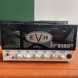 Černý kytarový zesilovač s kovovou mřížkou, na které je umístěno logo EVH a nápis 5150 III. Přední bílý panel obsahuje vstup INSERT, pět bílých otočn…